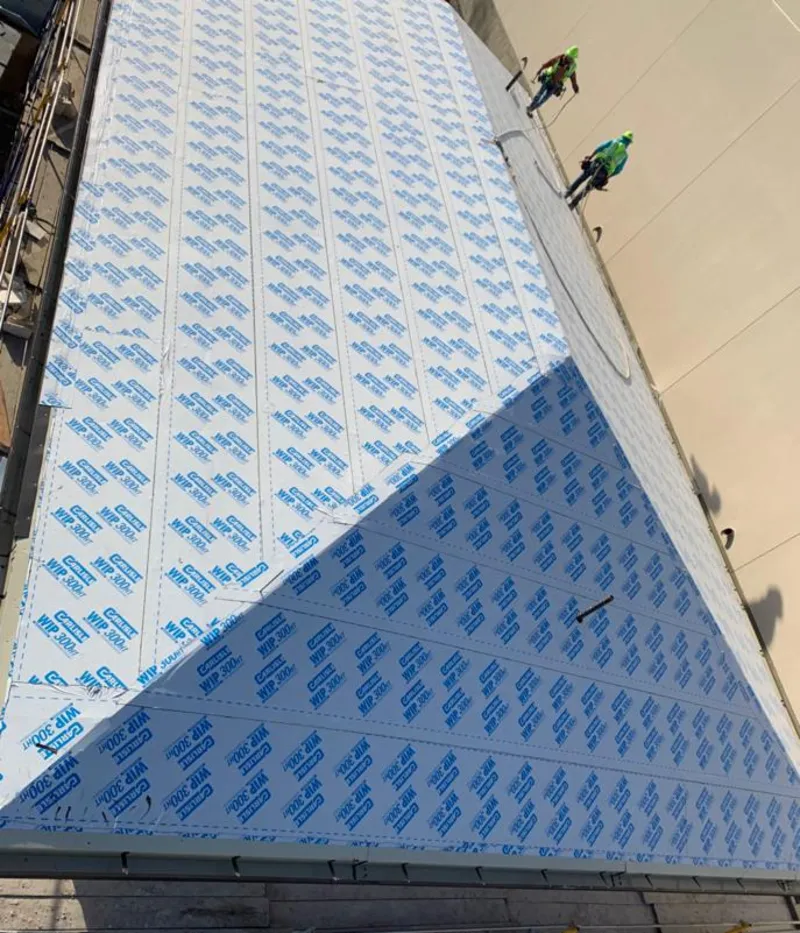 Professional roofers installing underlayment on a metal roof in Kent